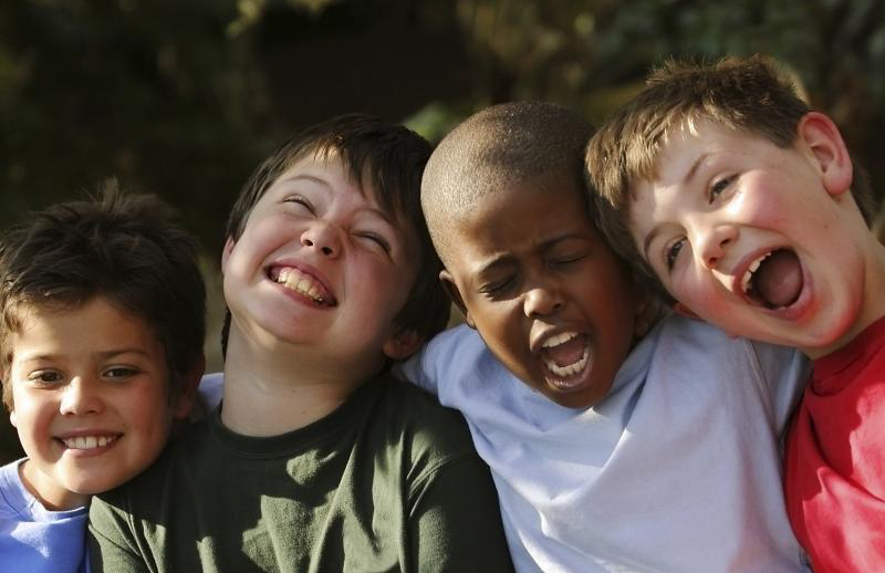 group of four boys laughing
